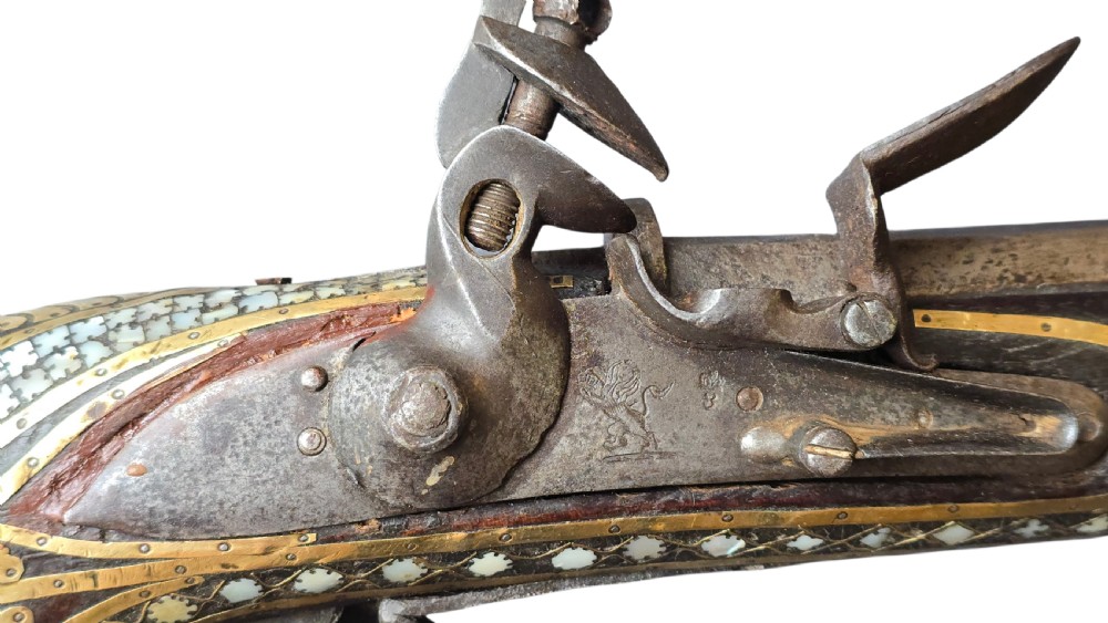 A late 18th-century Indo-Persian flintlock musket featuring a curved wooden stock inlaid with mother-of-pearl geometric patterns and bound with brass barrel bands. View IX