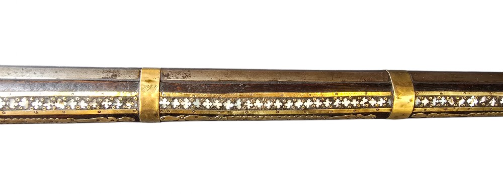 A late 18th-century Indo-Persian flintlock musket featuring a curved wooden stock inlaid with mother-of-pearl geometric patterns and bound with brass barrel bands. View XII
