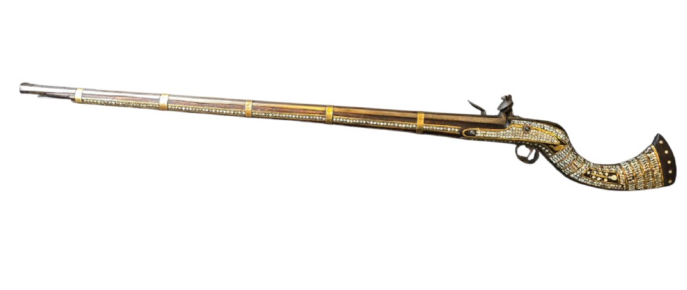 A late 18th-century Indo-Persian flintlock musket featuring a curved wooden stock inlaid with mother-of-pearl geometric patterns and bound with brass barrel bands. View XIV