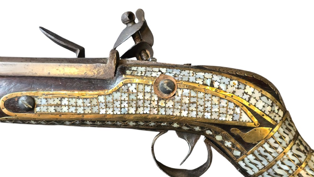 A late 18th-century Indo-Persian flintlock musket featuring a curved wooden stock inlaid with mother-of-pearl geometric patterns and bound with brass barrel bands. View XVI