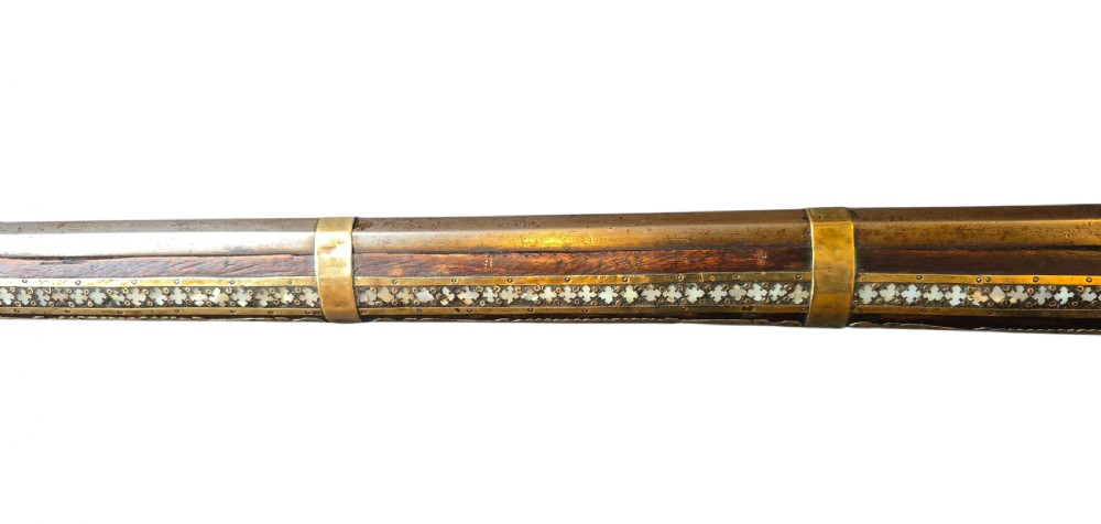 A late 18th-century Indo-Persian flintlock musket featuring a curved wooden stock inlaid with mother-of-pearl geometric patterns and bound with brass barrel bands. View XVII