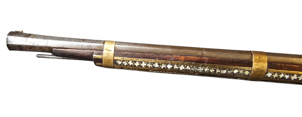 A late 18th-century Indo-Persian flintlock musket featuring a curved wooden stock inlaid with mother-of-pearl geometric patterns and bound with brass barrel bands. View XVIII