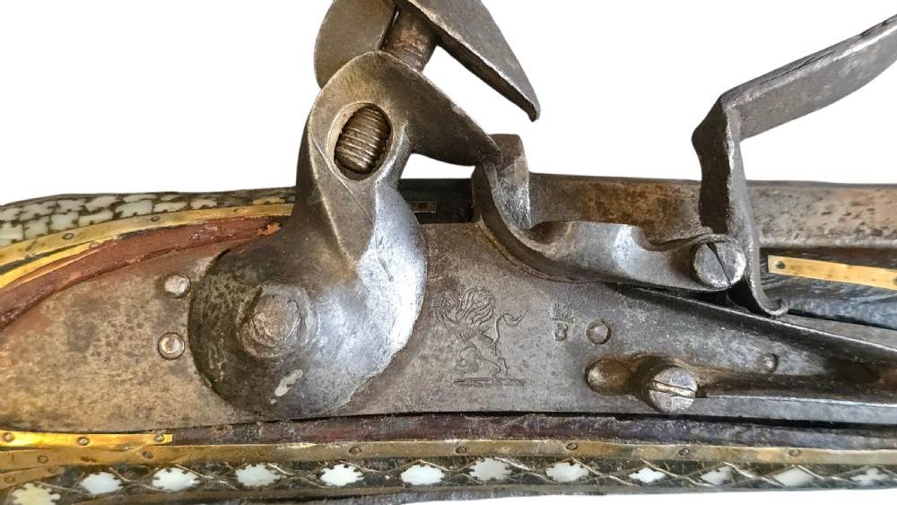 A late 18th-century Indo-Persian flintlock musket featuring a curved wooden stock inlaid with mother-of-pearl geometric patterns and bound with brass barrel bands. View XXI