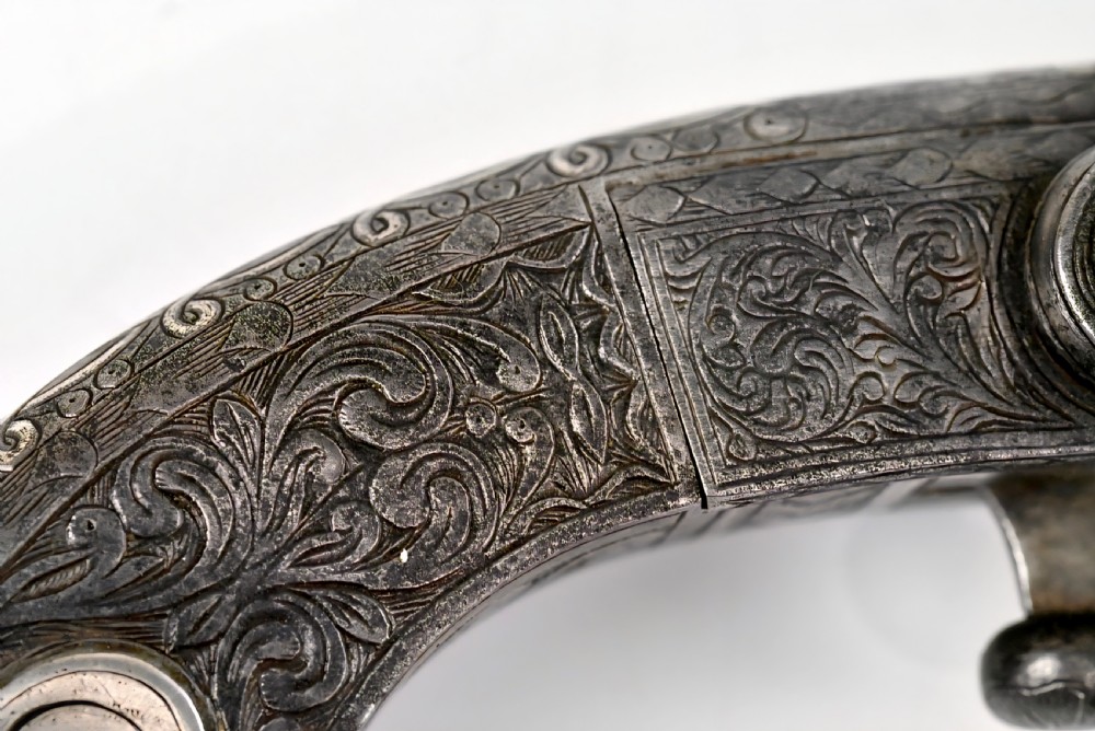 An 18th-century Scottish all-steel scroll-butt flintlock pistol with intricate surface engravings and a ramshorn terminal. View IX