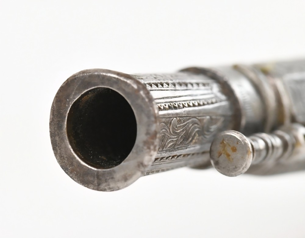 An 18th-century Scottish all-steel scroll-butt flintlock pistol with intricate surface engravings and a ramshorn terminal. View X