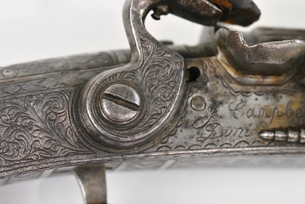An 18th-century Scottish all-steel scroll-butt flintlock pistol with intricate surface engravings and a ramshorn terminal. View XI