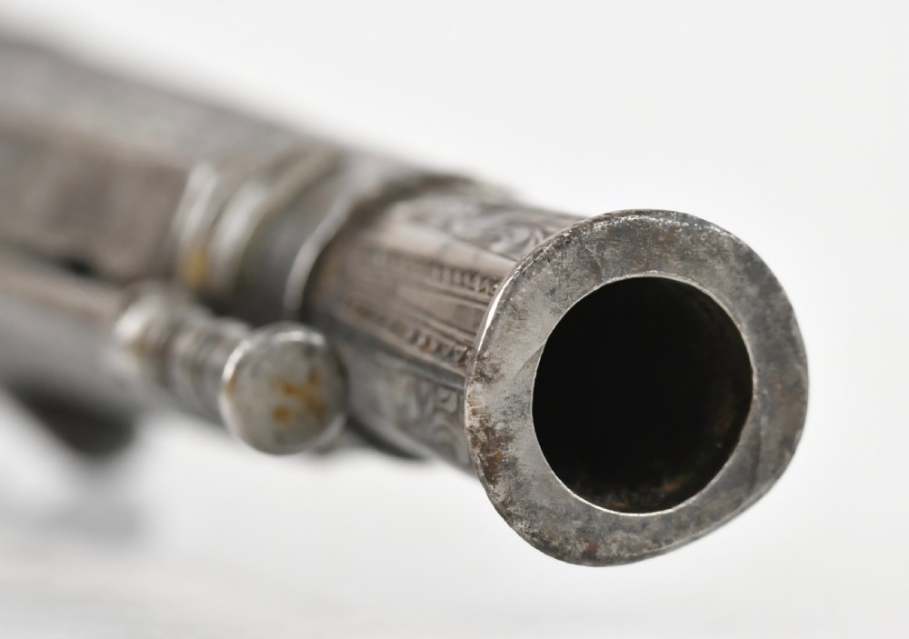 An 18th-century Scottish all-steel scroll-butt flintlock pistol with intricate surface engravings and a ramshorn terminal. View XV