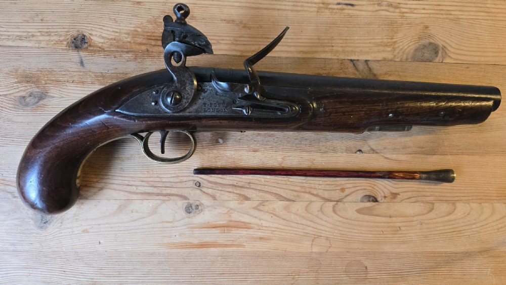 An 18th-century British flintlock cavalry pistol featuring a dark walnut stock, a dark steel barrel, and a lock plate engraved with T. Potts London. View XIII