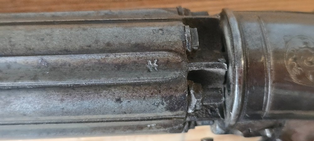 A nineteenth-century six-shot percussion pepperbox pistol featuring a multi-barrel steel cylinder, engraved frame, ring trigger, and chequered dark wood grip. View XXVI