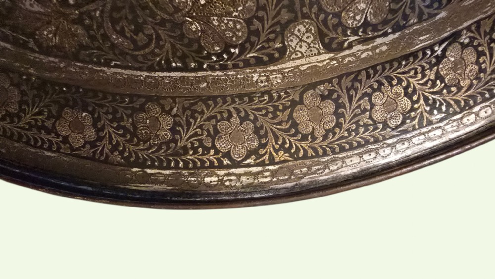 A circular late 19th-century Indian brass dhal shield featuring four central raised bosses and detailed engraved foliate patterns. View V