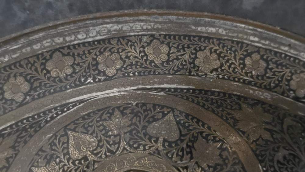 A circular late 19th-century Indian brass dhal shield featuring four central raised bosses and detailed engraved foliate patterns. View VI