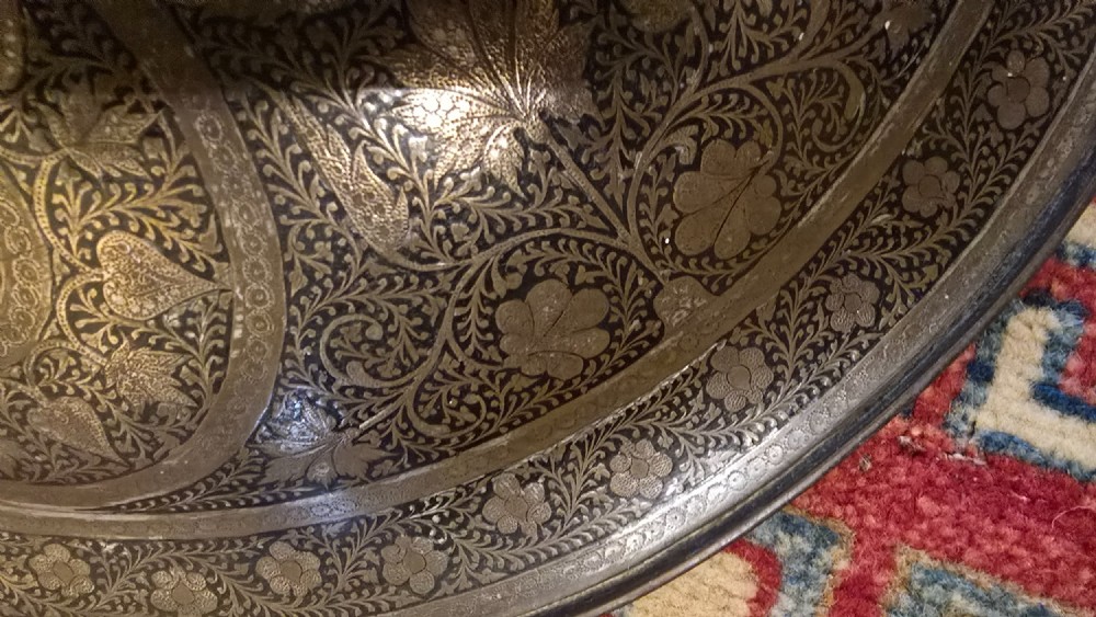A circular late 19th-century Indian brass dhal shield featuring four central raised bosses and detailed engraved foliate patterns. View IX