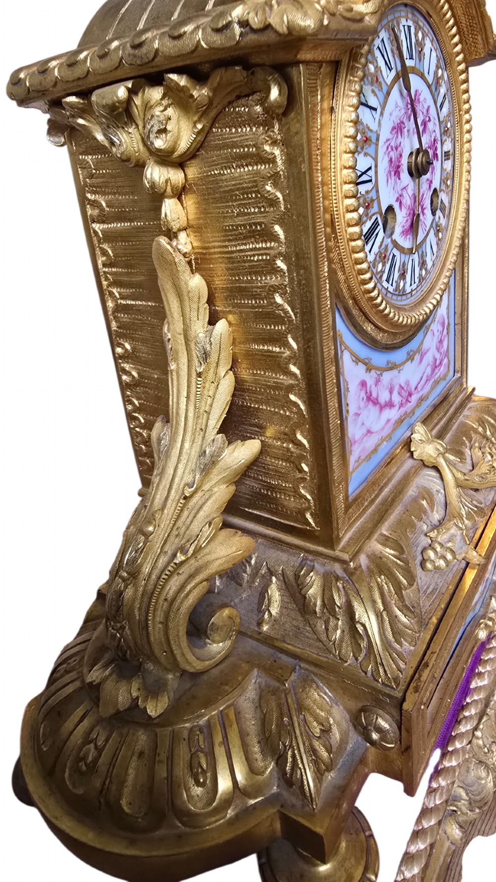 A French gilt bronze mantel clock decorated with hand-painted pink floral and cherub porcelain panels and topped with an urn flanked by swan handles. View XII