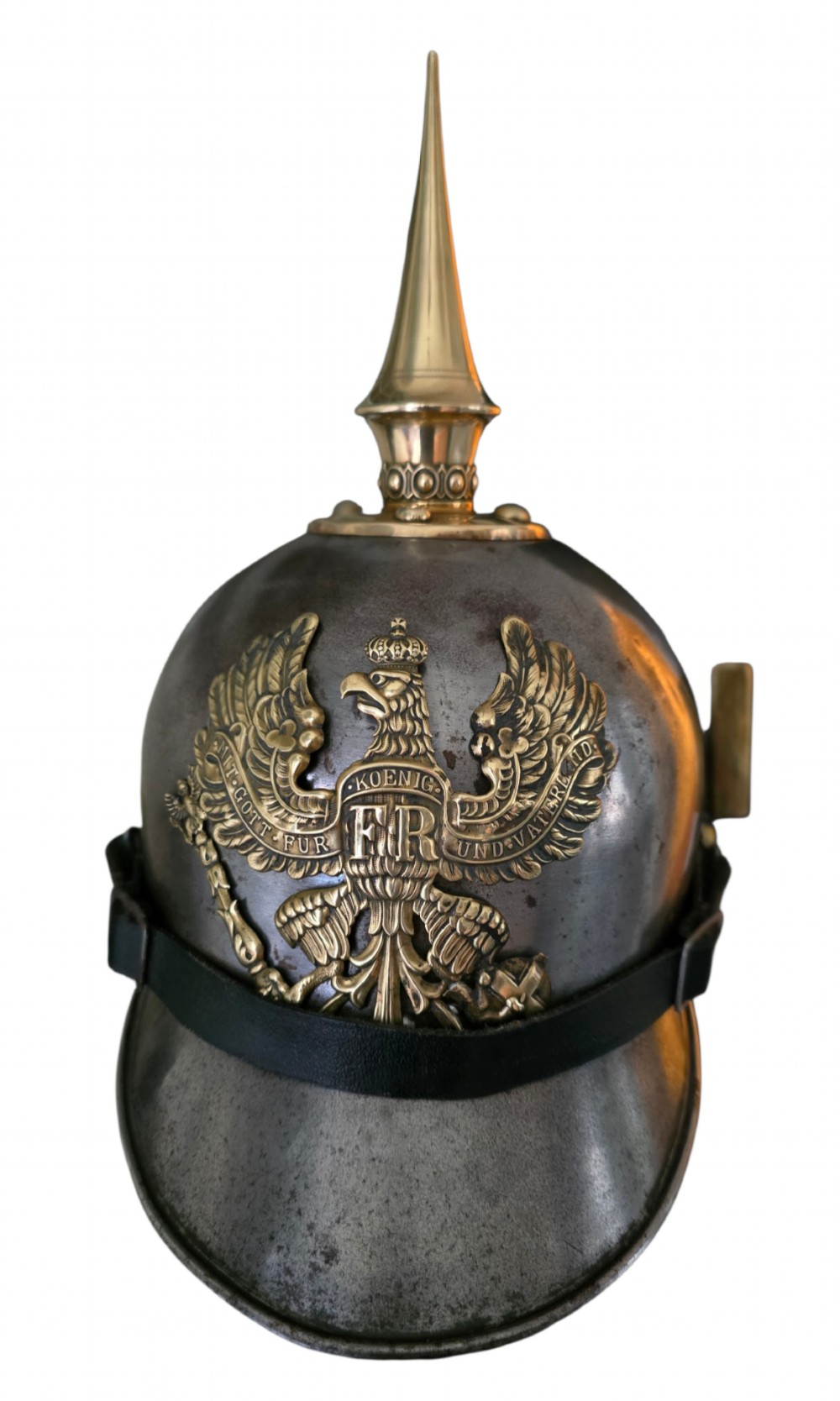 A WWI Prussian steel Pickelhaube helmet featuring a brass spiked top, a brass Prussian eagle emblem on the front, and a black strap.