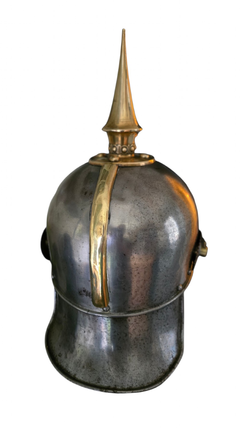 A WWI Prussian steel Pickelhaube helmet featuring a brass spiked top, a brass Prussian eagle emblem on the front, and a black strap. View IV