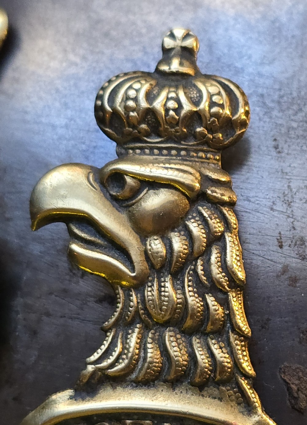 A WWI Prussian steel Pickelhaube helmet featuring a brass spiked top, a brass Prussian eagle emblem on the front, and a black strap. View IX