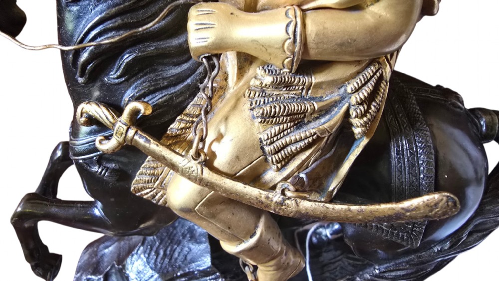 A 19th-century French mantel clock featuring a patinated and gilt bronze equestrian statue of Napoleon Bonaparte atop a base housing a white clock face with Roman numerals. View VI