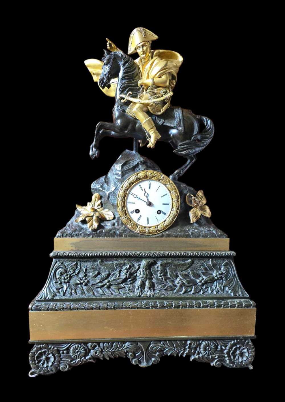 A 19th-century French mantel clock featuring a patinated and gilt bronze equestrian statue of Napoleon Bonaparte atop a base housing a white clock face with Roman numerals. View XIII