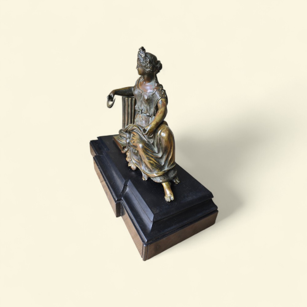 A 19th-century patinated bronze sculpture depicting the classical goddess Demeter seated beside a fluted column on a black stepped plinth. View IV