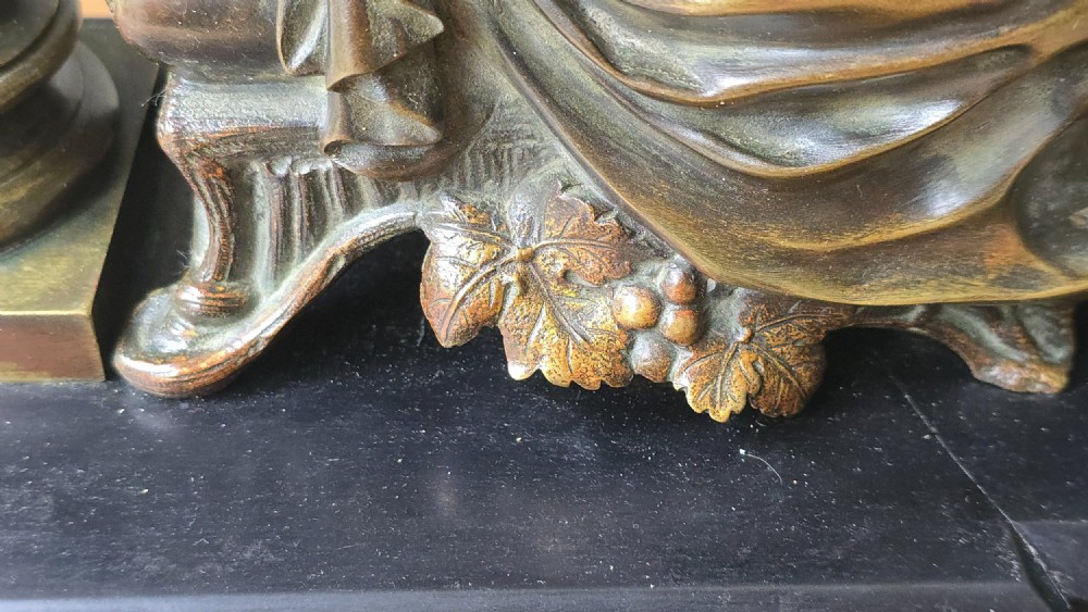 A 19th-century patinated bronze sculpture depicting the classical goddess Demeter seated beside a fluted column on a black stepped plinth. View V