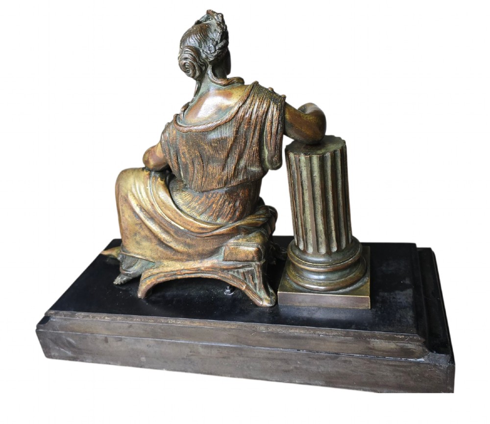 A 19th-century patinated bronze sculpture depicting the classical goddess Demeter seated beside a fluted column on a black stepped plinth. View X