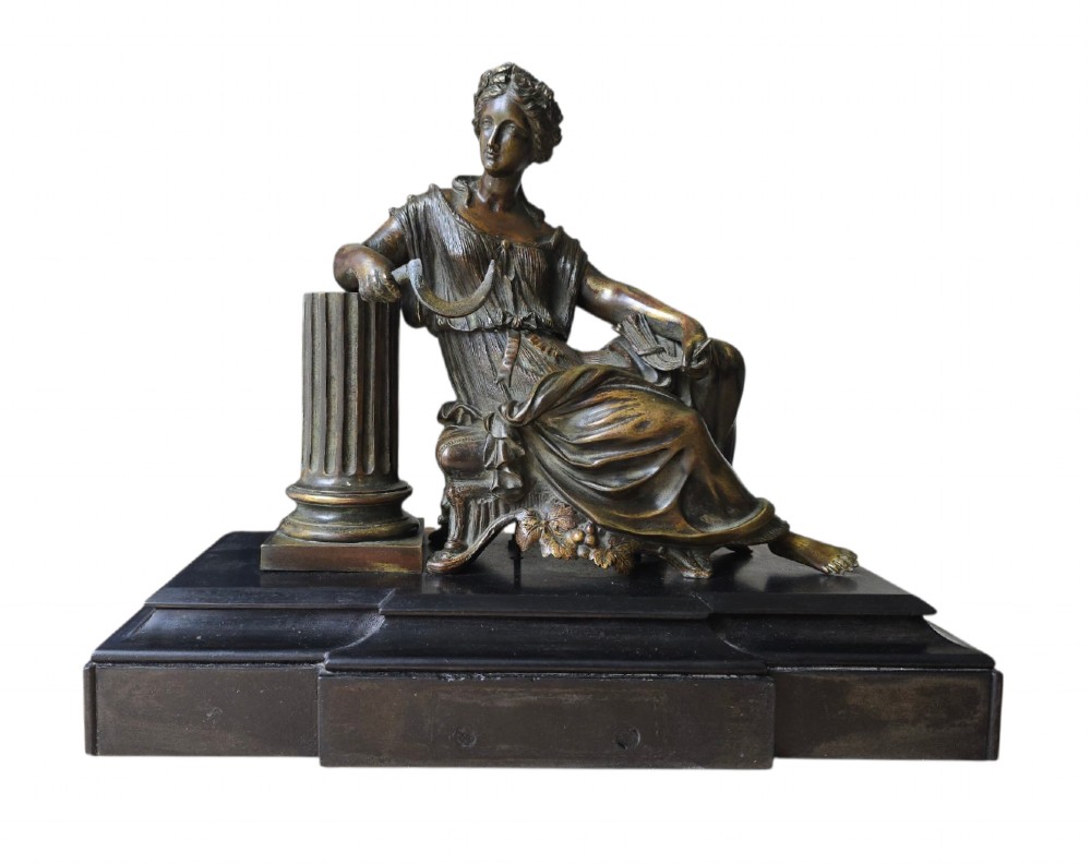 A 19th-century patinated bronze sculpture depicting the classical goddess Demeter seated beside a fluted column on a black stepped plinth. View XII