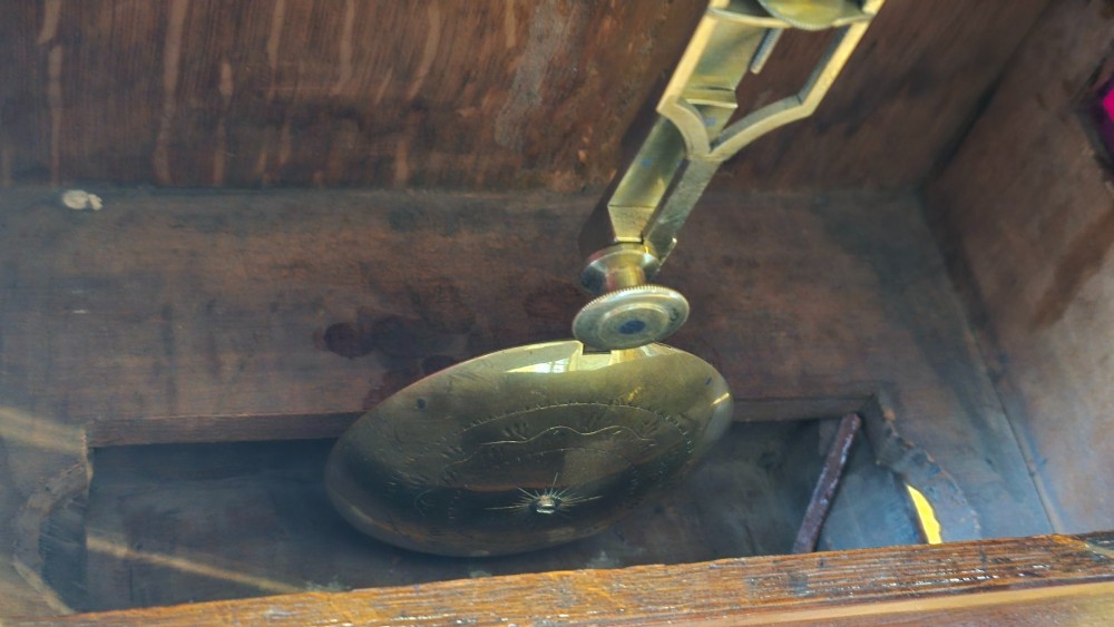 A Georgian mahogany lancet-top bracket clock featuring ebonised inlay, brass lion mask side handles, and decorative brass claw feet. View VI
