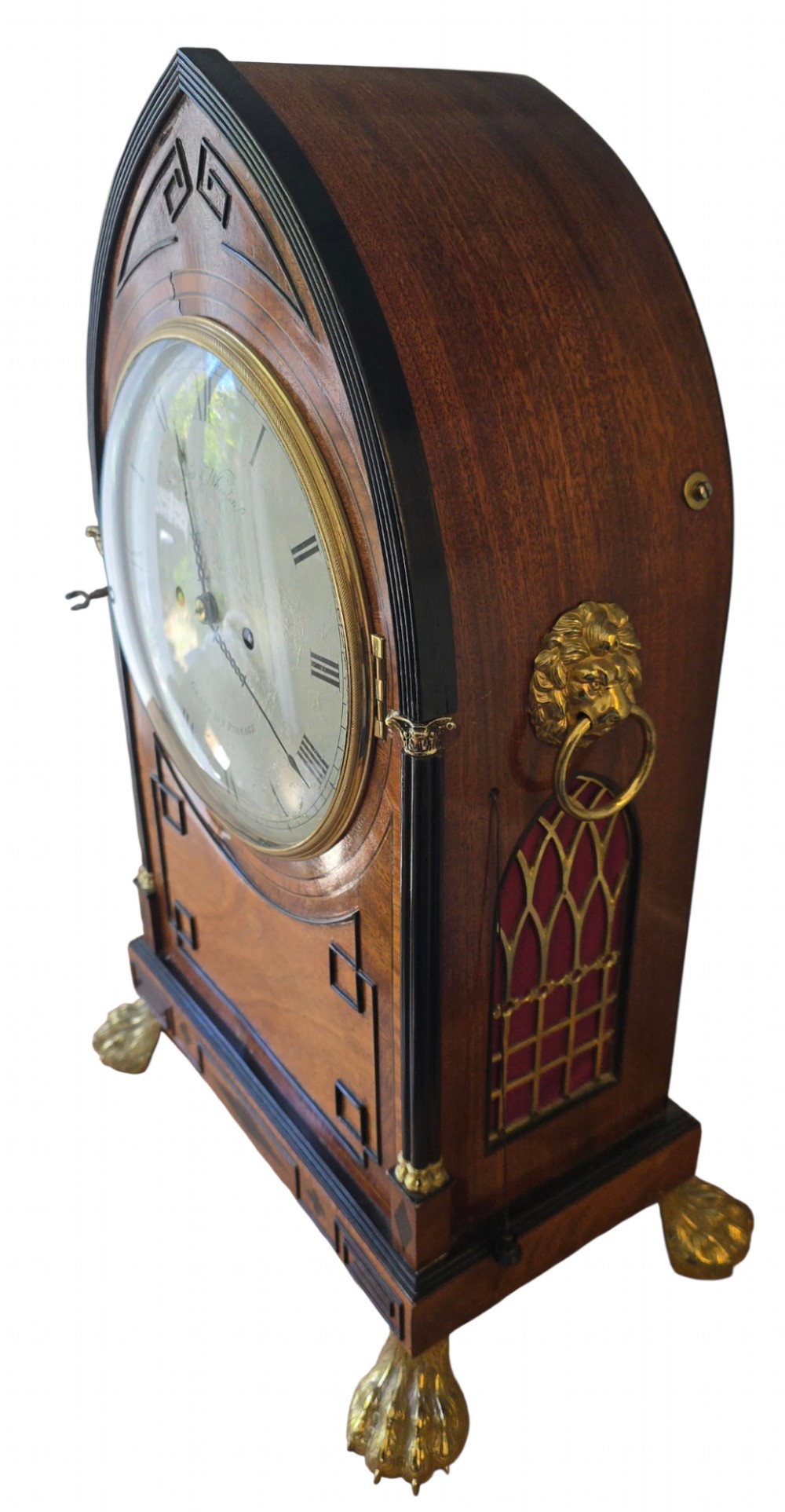 A Georgian mahogany lancet-top bracket clock featuring ebonised inlay, brass lion mask side handles, and decorative brass claw feet. View VIII