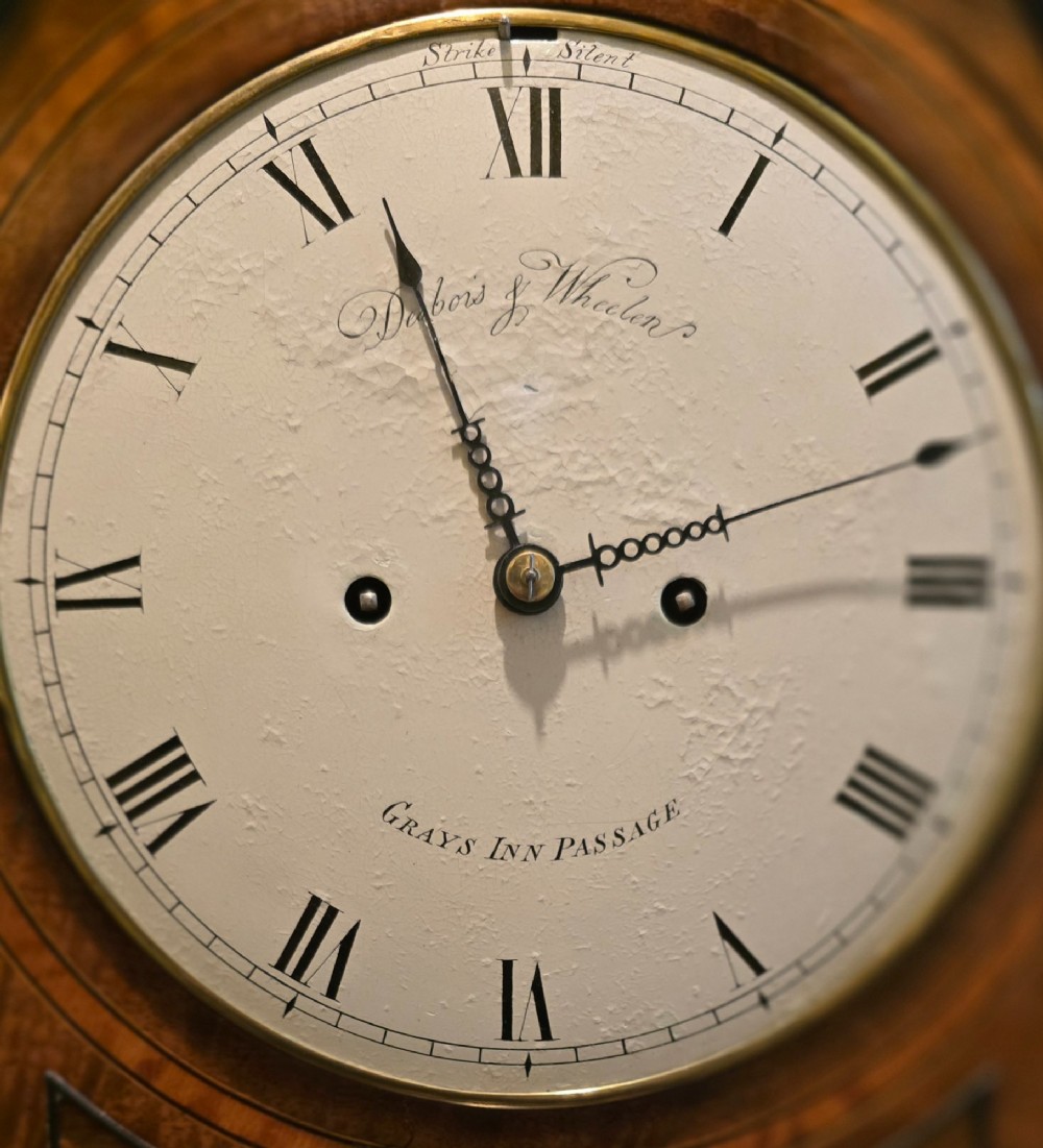 A Georgian mahogany lancet-top bracket clock featuring ebonised inlay, brass lion mask side handles, and decorative brass claw feet. View XIII