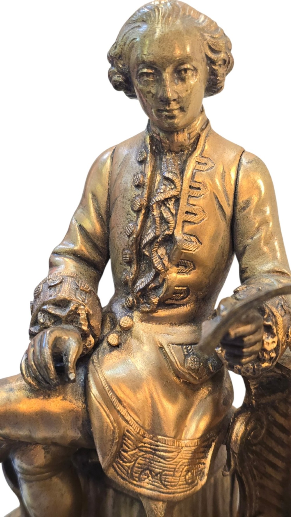 A 19th-century French gilt bronze sculpture depicting a seated gentleman in historic dress holding a quill, supported by an ornate black base with metallic scroll feet. View IV