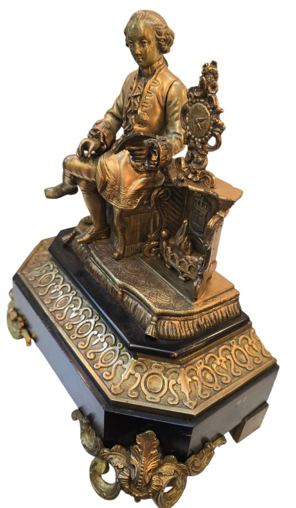 A 19th-century French gilt bronze sculpture depicting a seated gentleman in historic dress holding a quill, supported by an ornate black base with metallic scroll feet. View XII