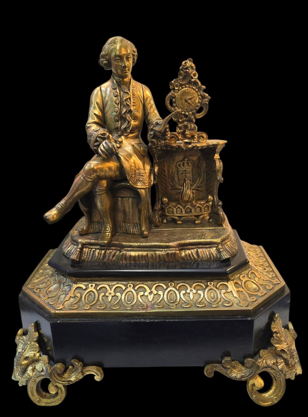 A 19th-century French gilt bronze sculpture depicting a seated gentleman in historic dress holding a quill, supported by an ornate black base with metallic scroll feet. View XIII
