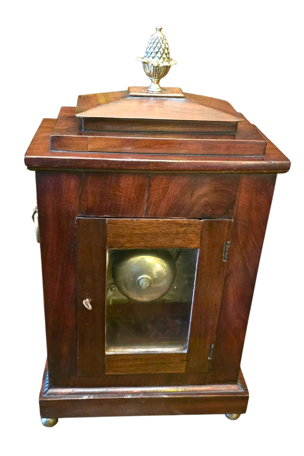 A Georgian mahogany bracket clock featuring brass star and floral motifs, a pineapple finial, brass ball feet, and a white dial marked Taylor London with Roman numerals. View X