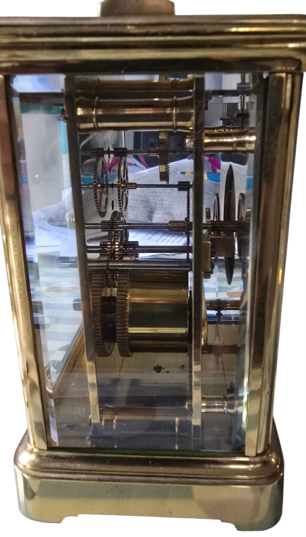 A rectangular French gilt-brass carriage clock featuring bevelled glass panels, a white enamel dial with Roman numerals, and a hinged top handle. View IV