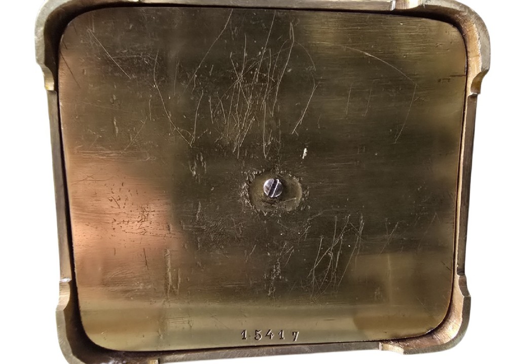 A rectangular French gilt-brass carriage clock featuring bevelled glass panels, a white enamel dial with Roman numerals, and a hinged top handle. View VIII
