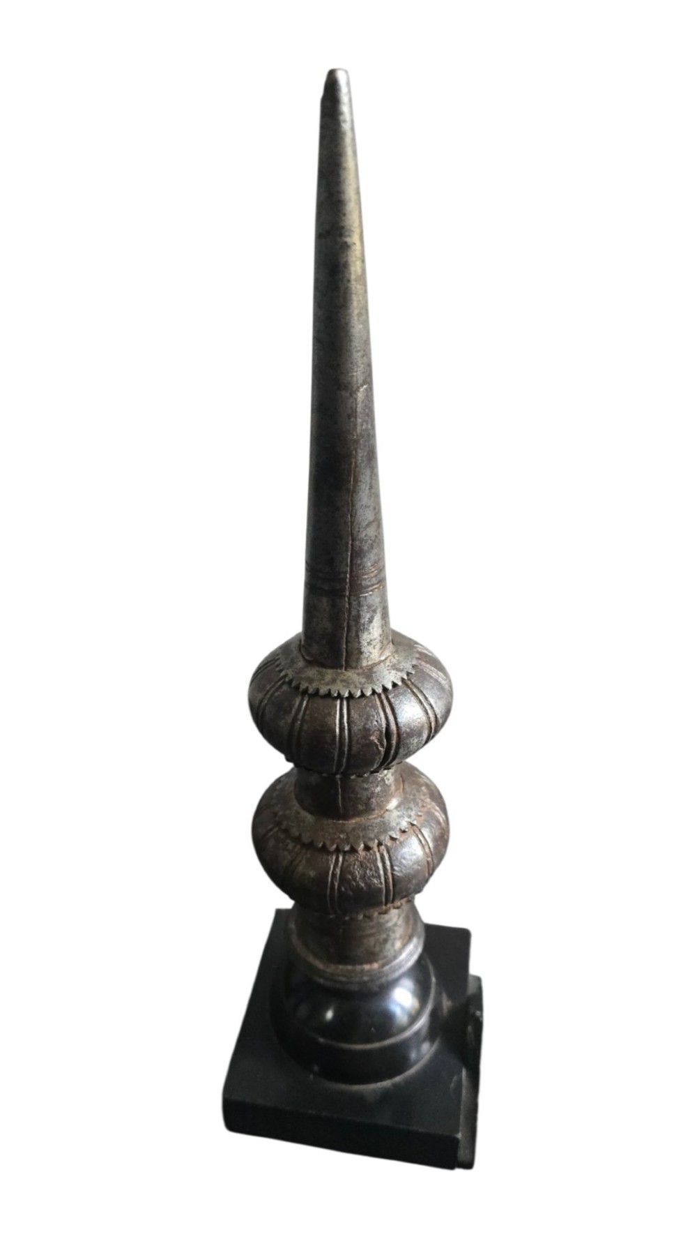 A 17th-century forged iron spear butt with a tapered spike and two ribbed knops, mounted vertically on a dark square stand.