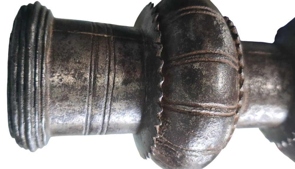 A 17th-century forged iron spear butt with a tapered spike and two ribbed knops, mounted vertically on a dark square stand. View IV