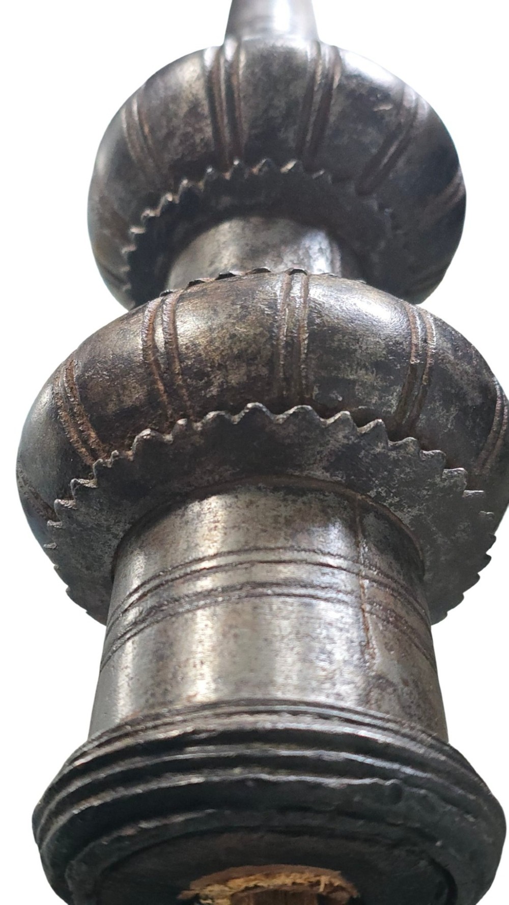 A 17th-century forged iron spear butt with a tapered spike and two ribbed knops, mounted vertically on a dark square stand. View X