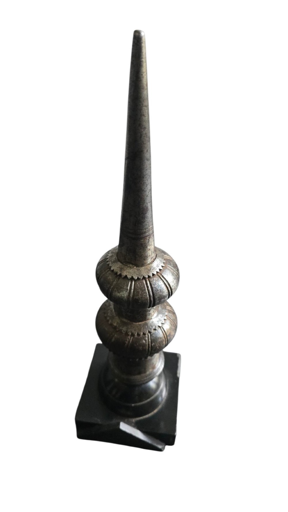 A 17th-century forged iron spear butt with a tapered spike and two ribbed knops, mounted vertically on a dark square stand. View XII