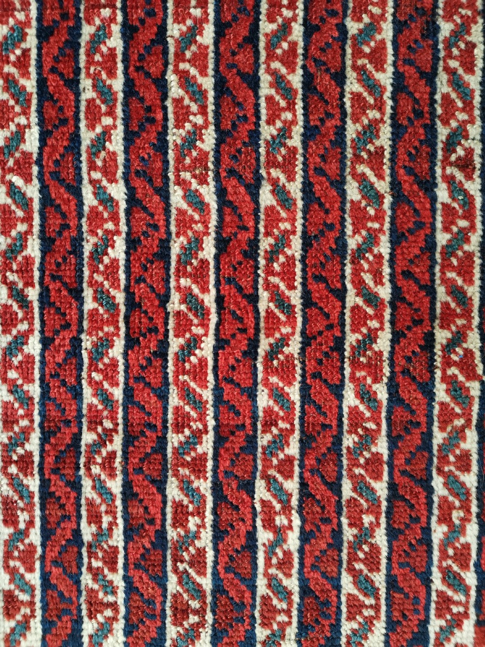 A rectangular hand-knotted antique Khamseh rug featuring vertical striped field patterns and two diamond-shaped medallions in deep red, indigo, and ivory wool. View V
