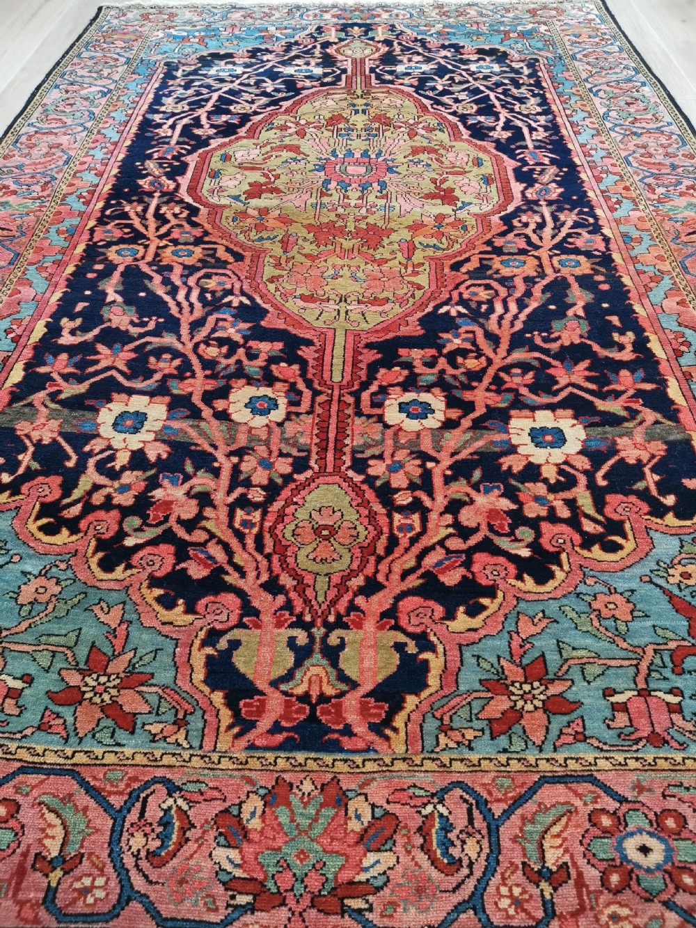 A hand-knotted antique Persian Mishan Malayer wool rug with a navy blue field, central olive medallion, and rose pink floral borders. View IV