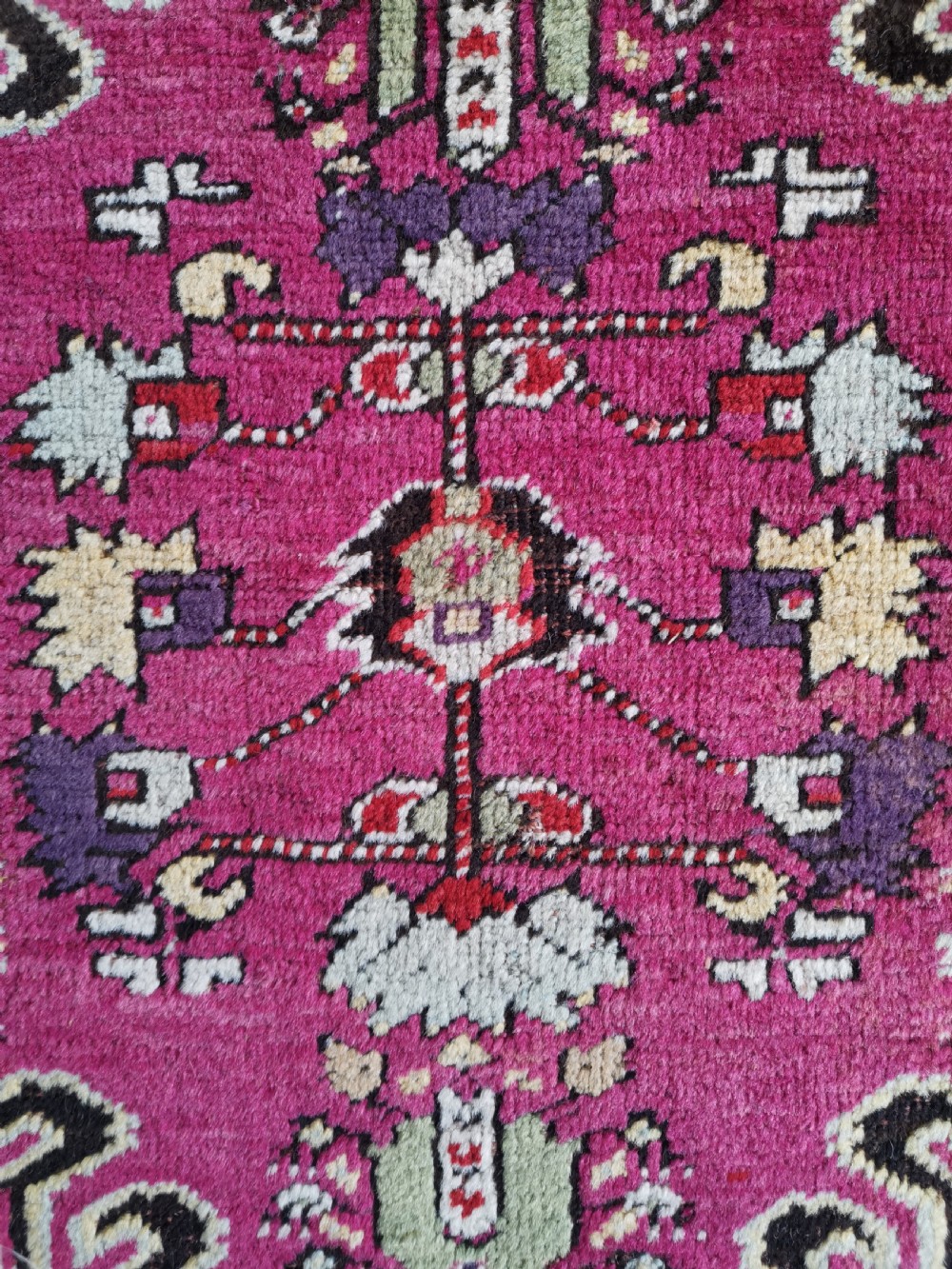 A hand-knotted Anatolian Kirsehir wool rug featuring a central magenta stepped medallion set within an olive green field and surrounded by multi-banded geometric borders. View III