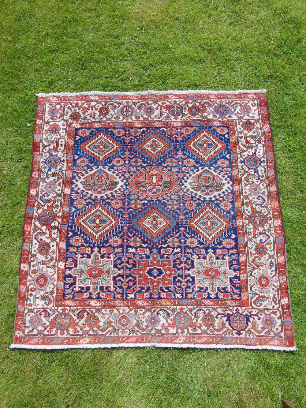 Hand-knotted antique Persian Karaja rug featuring a navy blue field with geometric diamond medallions, framed by multi-coloured decorative borders.