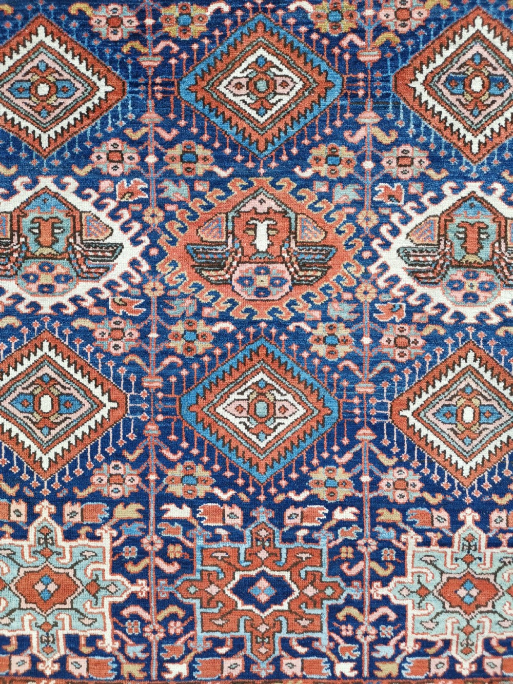 Hand-knotted antique Persian Karaja rug featuring a navy blue field with geometric diamond medallions, framed by multi-coloured decorative borders. View V