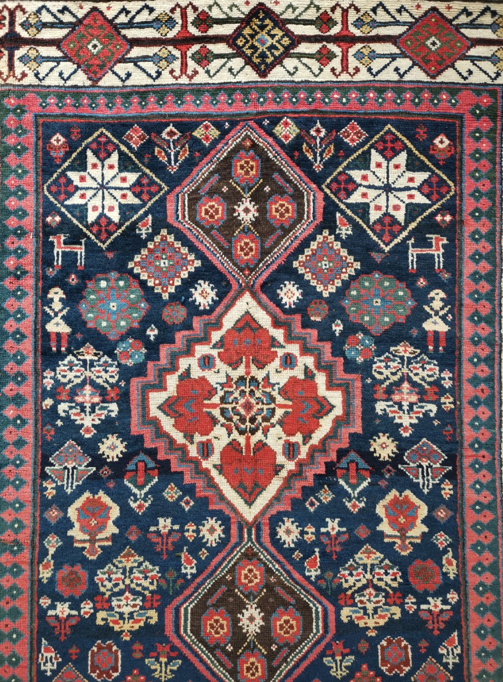 A hand-knotted Persian Veramin wool runner rug featuring diamond-shaped central medallions in crimson red, navy blue, and ivory set within a geometric border. View II