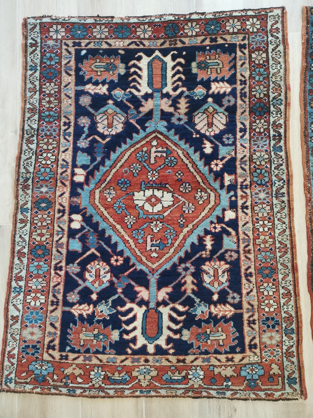 A hand-knotted antique Karaja wool rug featuring a navy field decorated with a central red geometric diamond medallion and colourful tribal motifs within a geometric border. View II