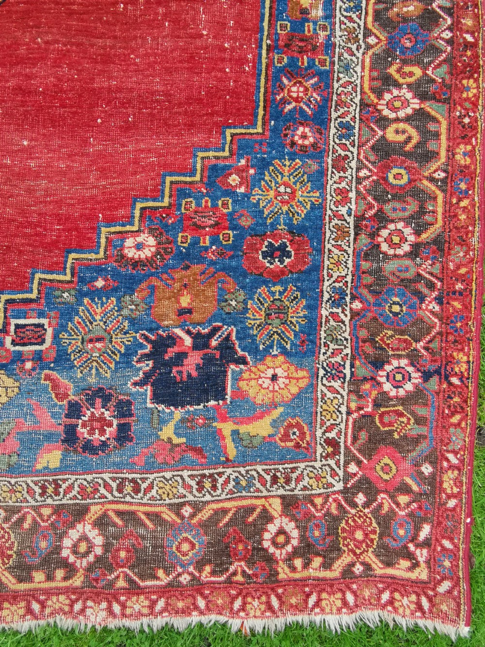 An antique hand-knotted Persian Bijar wool rug featuring a red central field, dark navy medallion, and geometric floral borders. View II