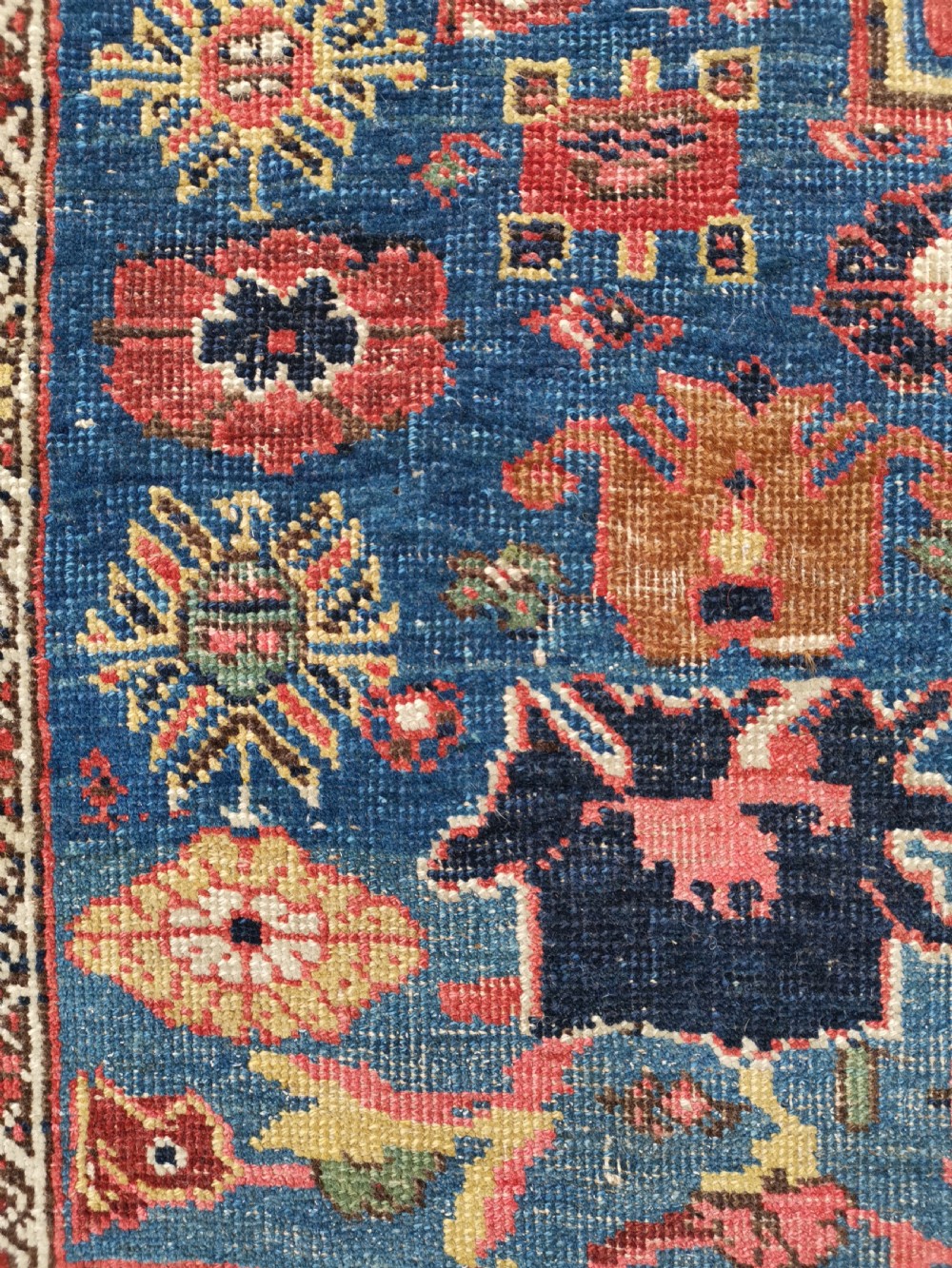 An antique hand-knotted Persian Bijar wool rug featuring a red central field, dark navy medallion, and geometric floral borders. View VII