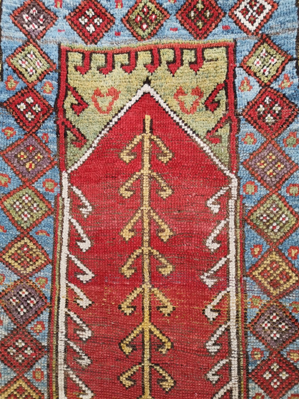 A hand-knotted antique Anatolian Konya prayer rug featuring a red mihrab arch motif, central tree pattern, and geometric multi-coloured borders. View VI