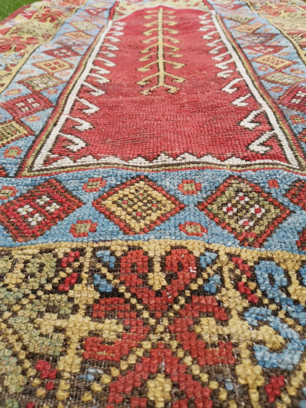 A hand-knotted antique Anatolian Konya prayer rug featuring a red mihrab arch motif, central tree pattern, and geometric multi-coloured borders. View VII